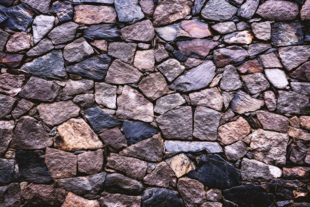 High-resolution image of a rustic stone wall showing detailed texture and pattern.